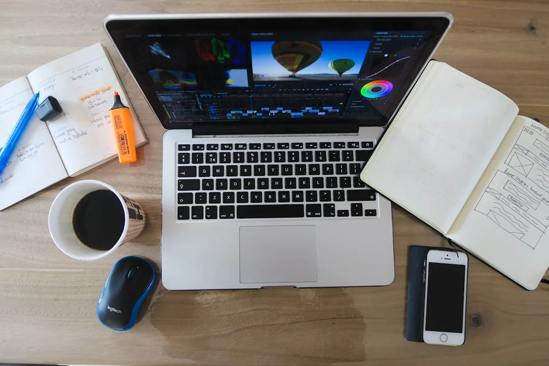 Un espace de travail moderne montrant des mains en train d’analyser des données marketing sur un ordinateur portable et des documents papier.